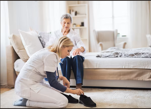 A carer helping a client with dressing at home with dignity